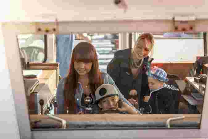 Zwei junge Frauen und zwei Kinder sind im Steuerhaus der MS Bismarckhöhe in Werder (Havel). Ein kleiner Junge dreht das Steuerrad und grinst.