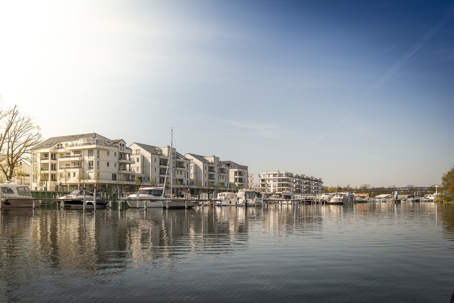 Der Stichhafen der Havelauen mit weißen Neubauten und liegenden Booten.